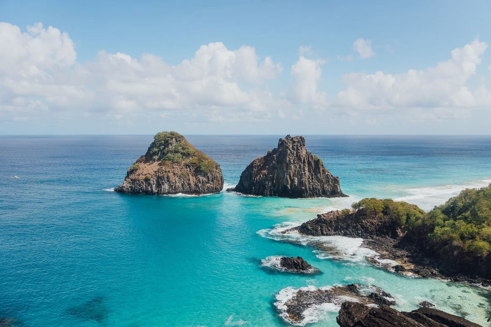 Os Dois Irmãos emergindo do mar turquesa em Fernando de Noronha.