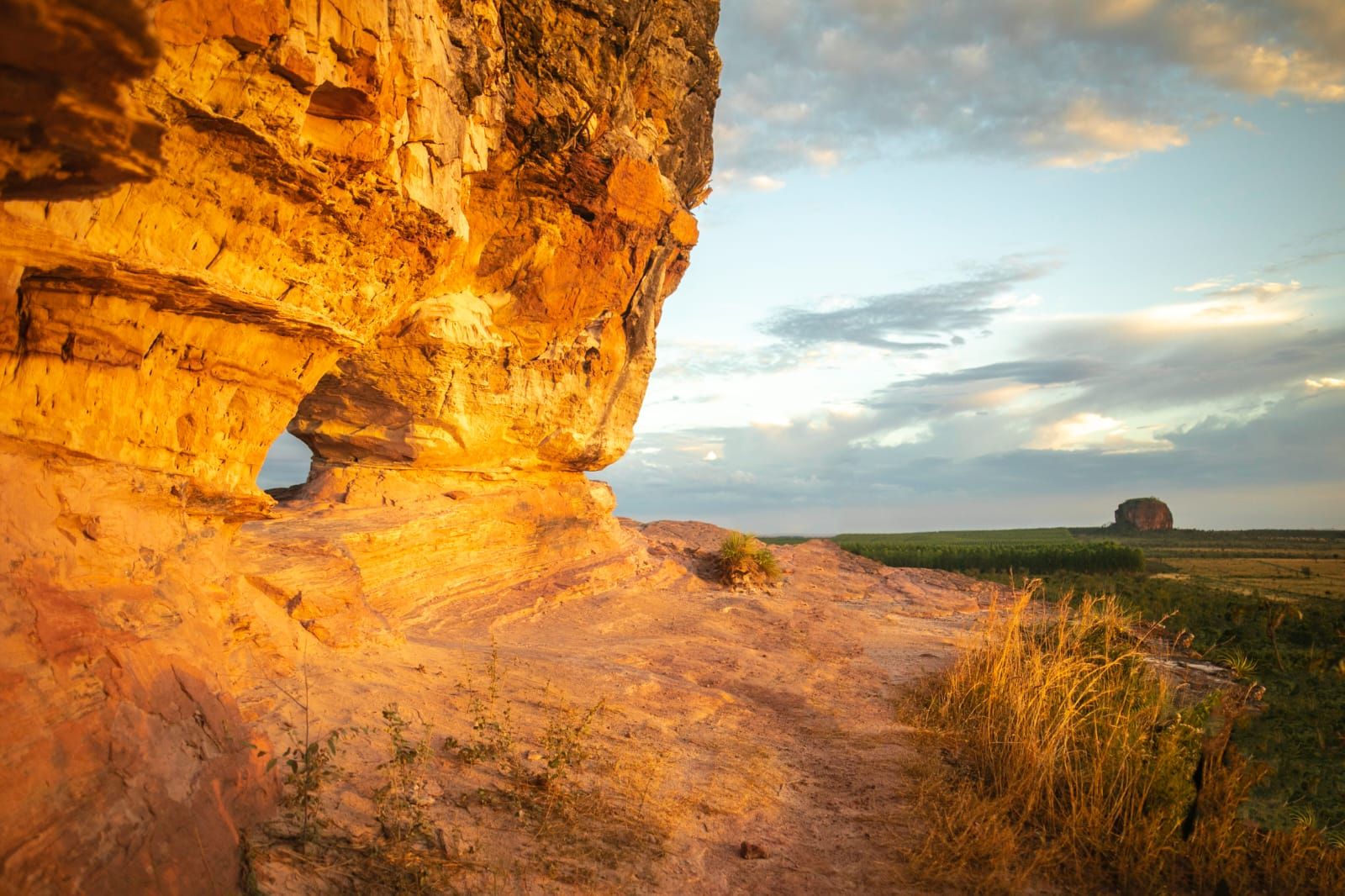 Formações de arenito douradas ao pôr do sol na paisagem aberta do Jalapão.