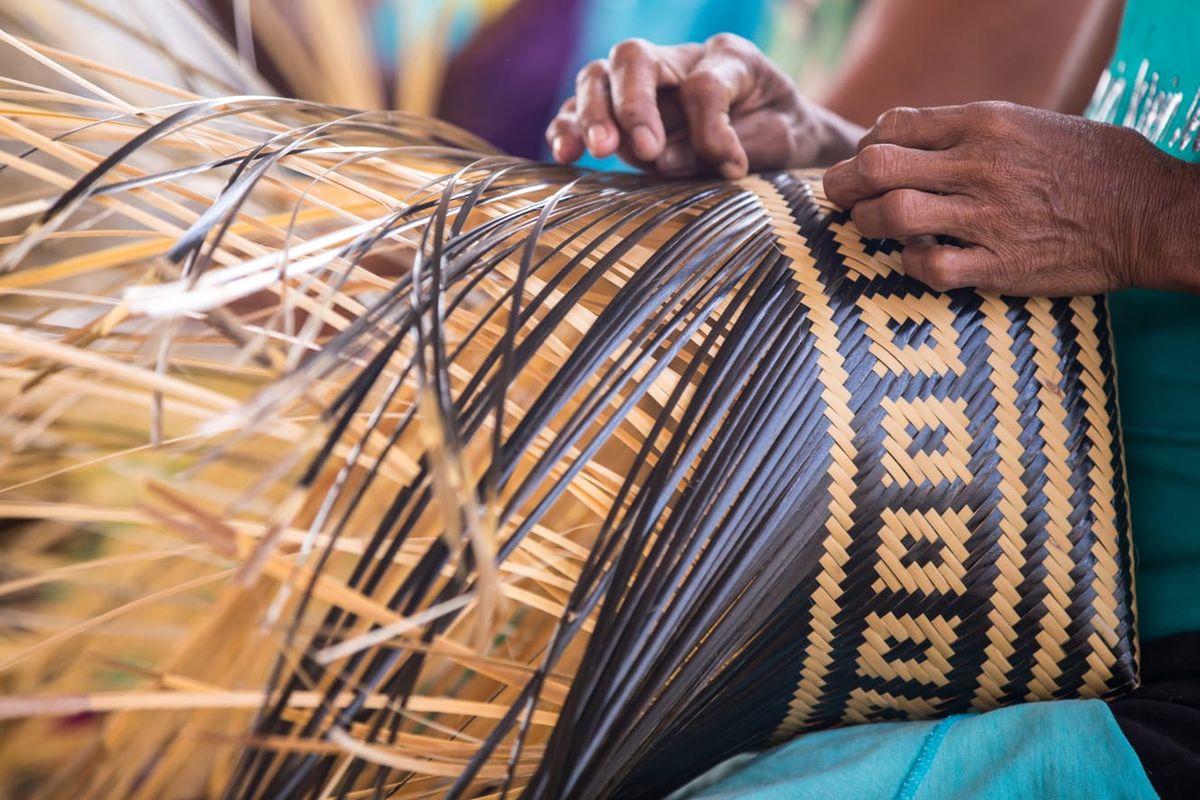 Mãos trançando uma peça de artesanato no Brasil — as pessoas por trás dos lugares.
